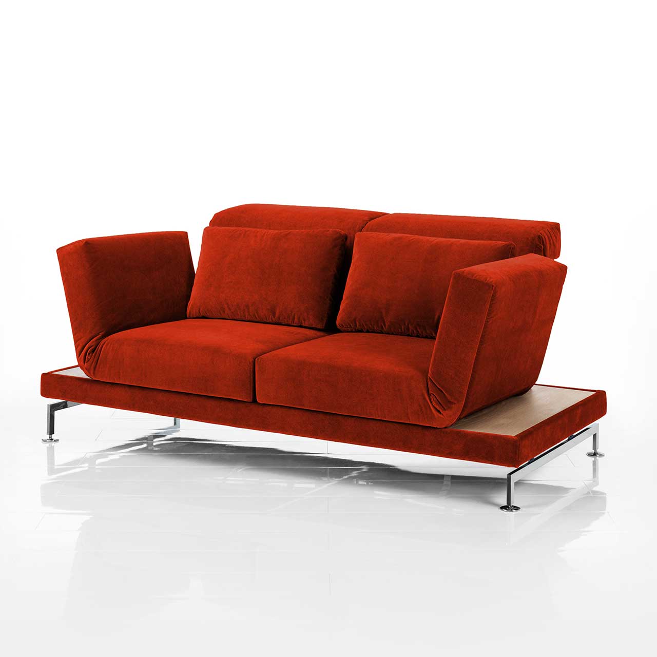 Sofa in rotem Stoff. Rechts und links neben den Armlehnen befinden sich schmale Ablageflächen in hellem Holz.