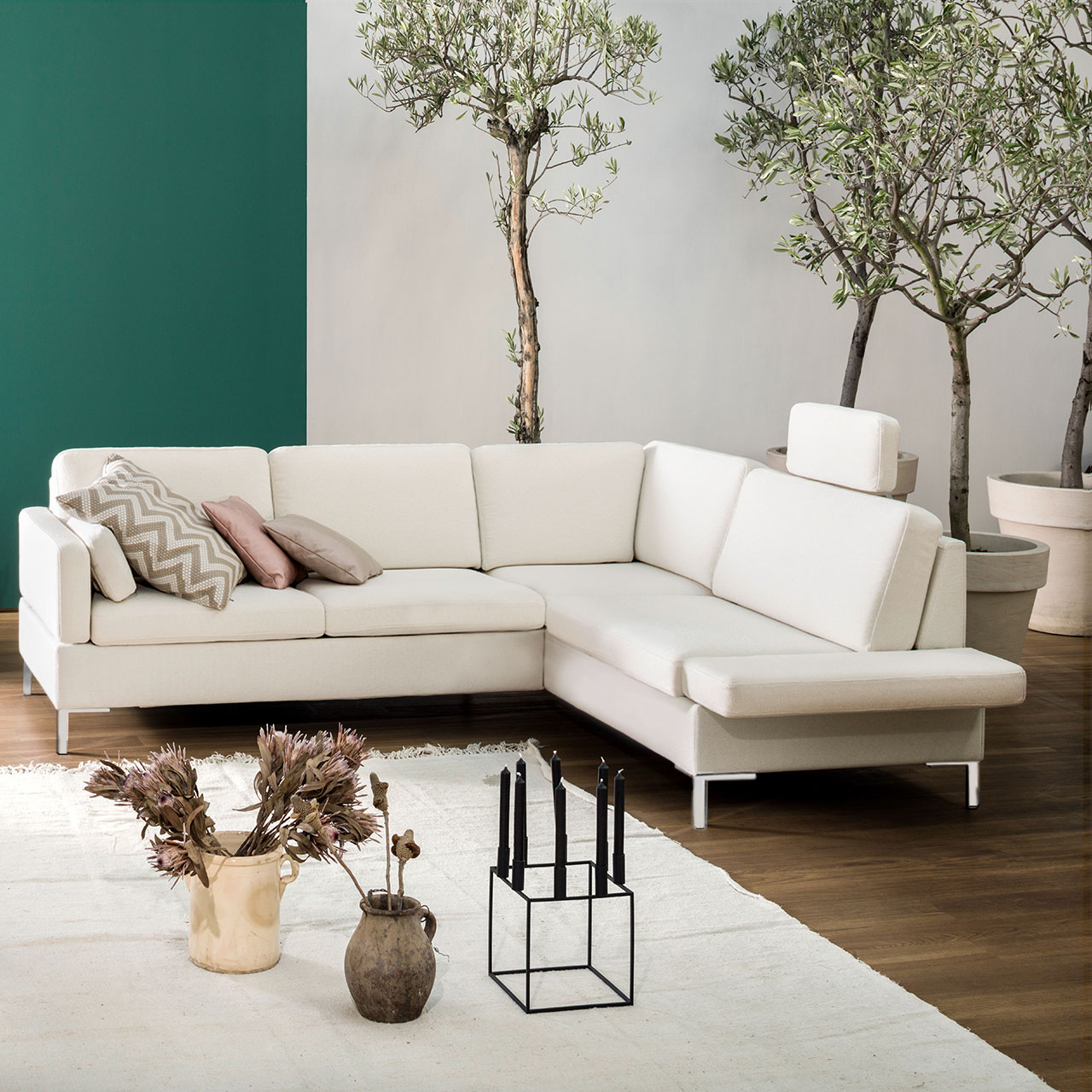 Ambientebild: Weiße Eckgarnitur mit Anstellsofa links und Eckanbausofa rechts.