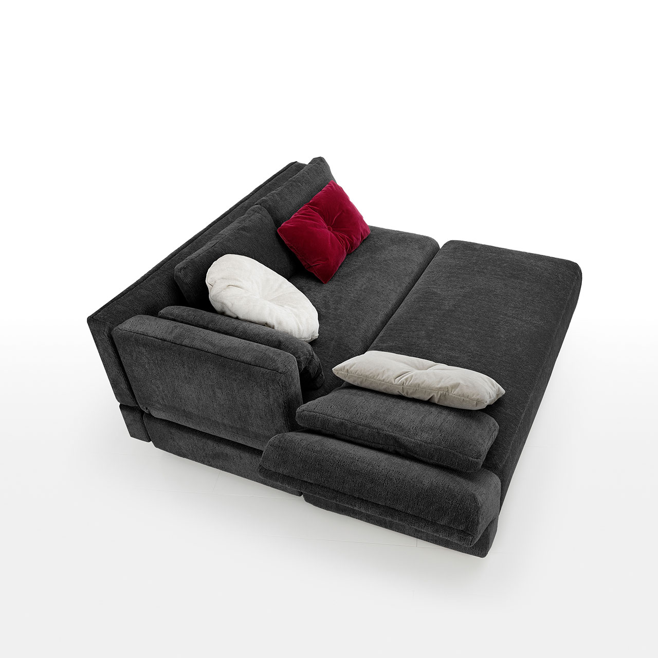 Rückansicht auf ein bodennahes schwarzes Eckofa mit Drehsofa rechts und Longchair links. Das Drehsofa ist zum Longchair vorgeschwenkt.