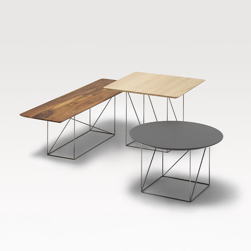 Drei Tische mit Drahtuntergestell und Tischplatten in hellem und dunklem Holz sowie aus grauem Stein.