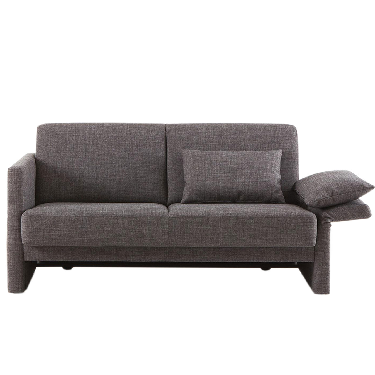 Ein braunes Bettsofa von brühl cara mit abgewinkelter Armlehne auf der rechten Seite. Auf dieser liegt eines der Rückenkissen wie ein Kopfkissen. Das zweite Rückenkissen ist an die Rückenlehne gelehnt.