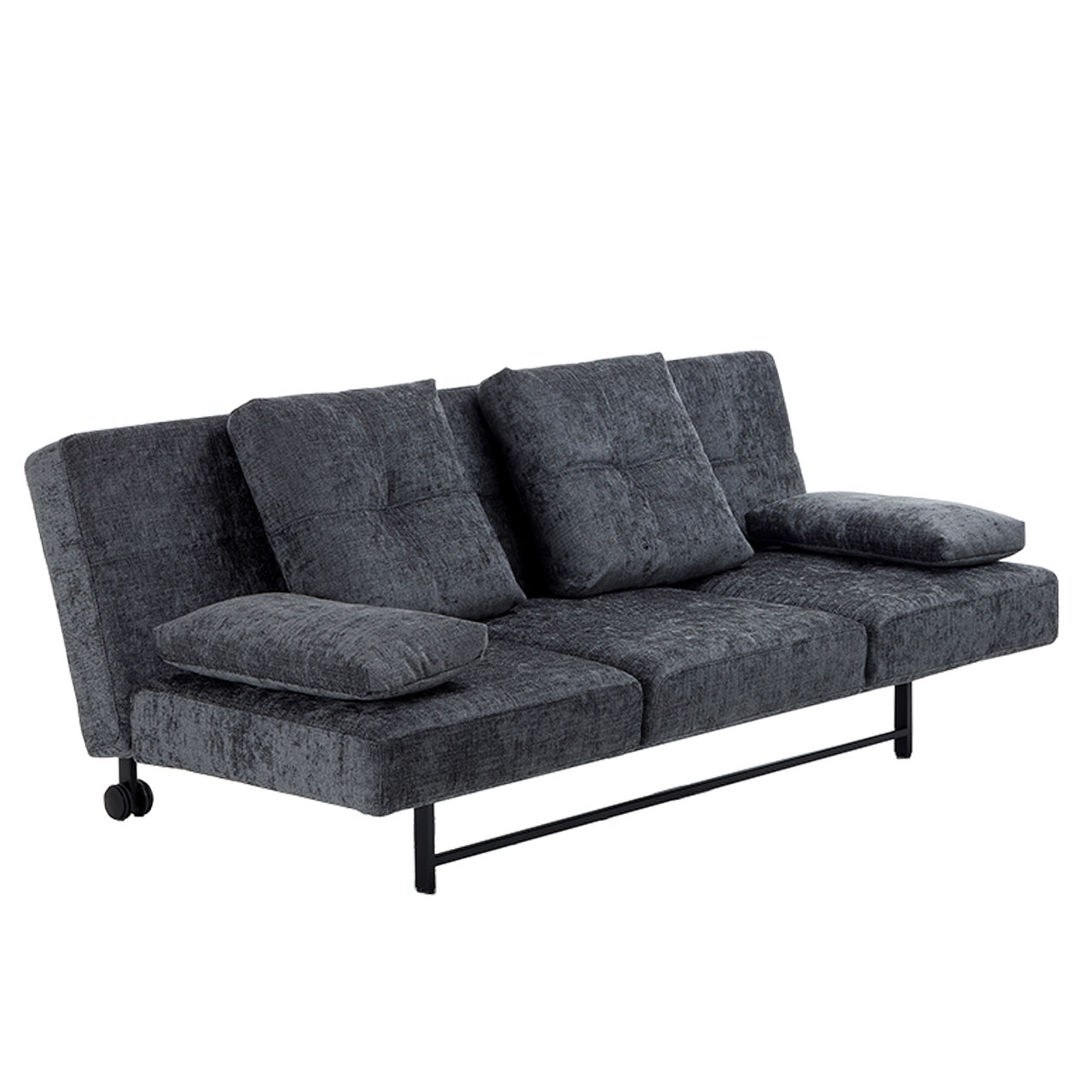 Leicht schräge Sicht auf ein Sofa in anthrazit. Das Sofa steht auf einem schwarzen Metallgestell mit Rollen an den hinteren Füßen. Auf dem Sofa stehen zwei große quadratische Kissen und an den Seiten liegen zwei kleinere, rechteckige Kissen als Armlehnen.