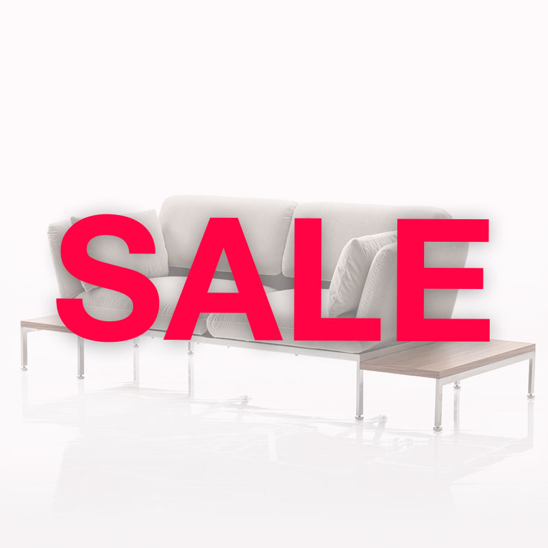 Im Hintergrund ist ein Sofa mit Beistelltischen. Davor ist der Schriftzug Sale in roter Schrift zu lesen. 