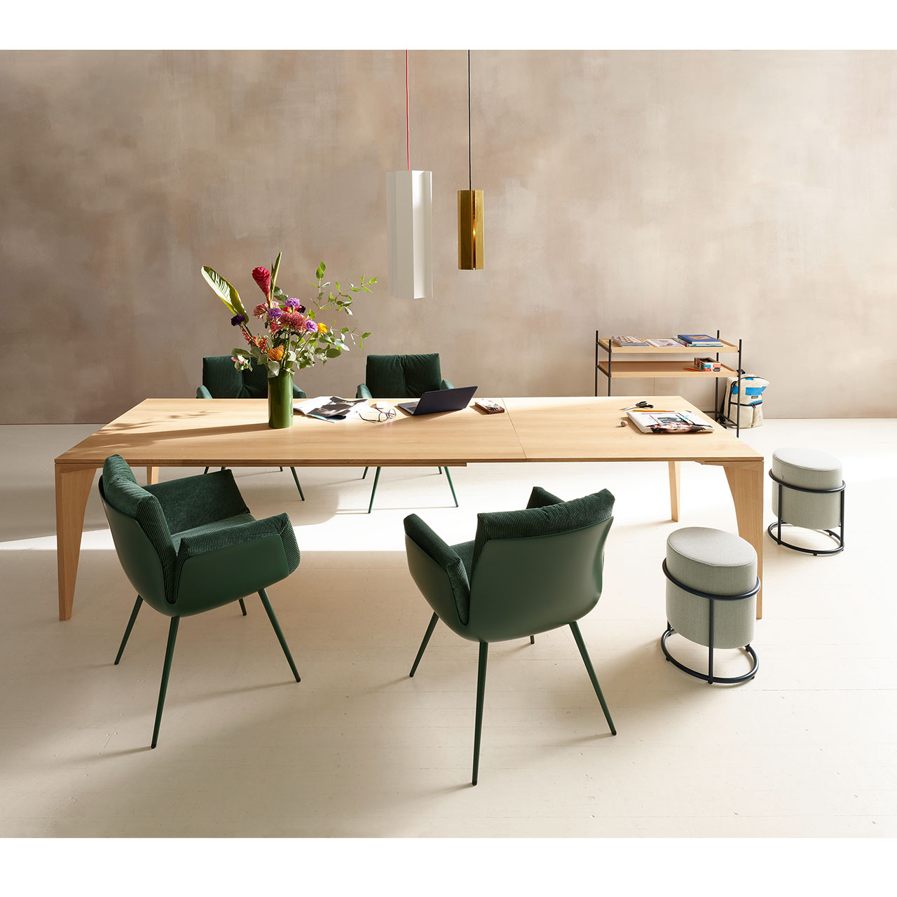 Zwei Hocker stehen neben vierbeinigen Stühlen an einem Holztisch