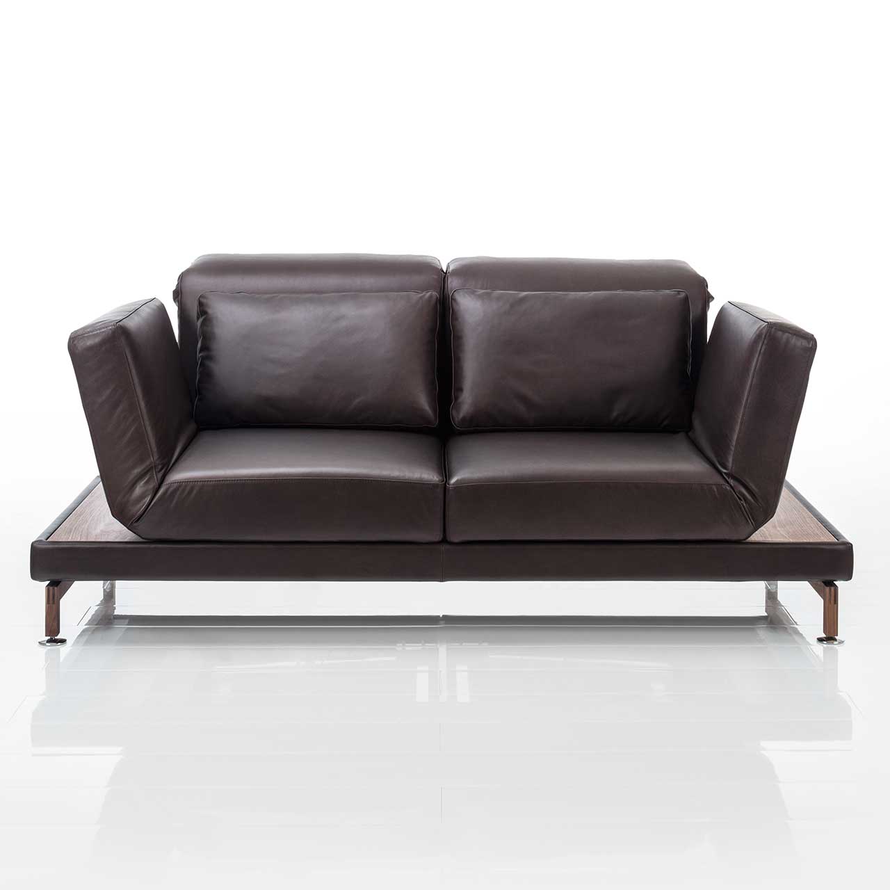 Dunkelbraunes Ledersofa. Rechts und links neben den Armlehnen befinden sich schmale Ablageflächen in dunklem Holz.