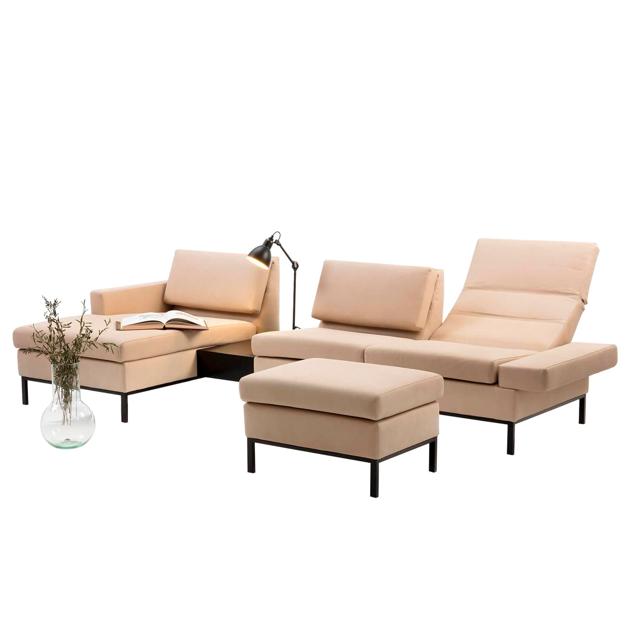 Eckgarnitur mit Longchair links und Einhängetisch. Vor dem Anstellsofa steht eine Fußbank. Die Polstermöbel sind in beigem Leder mit Untergestellen in schwarz.