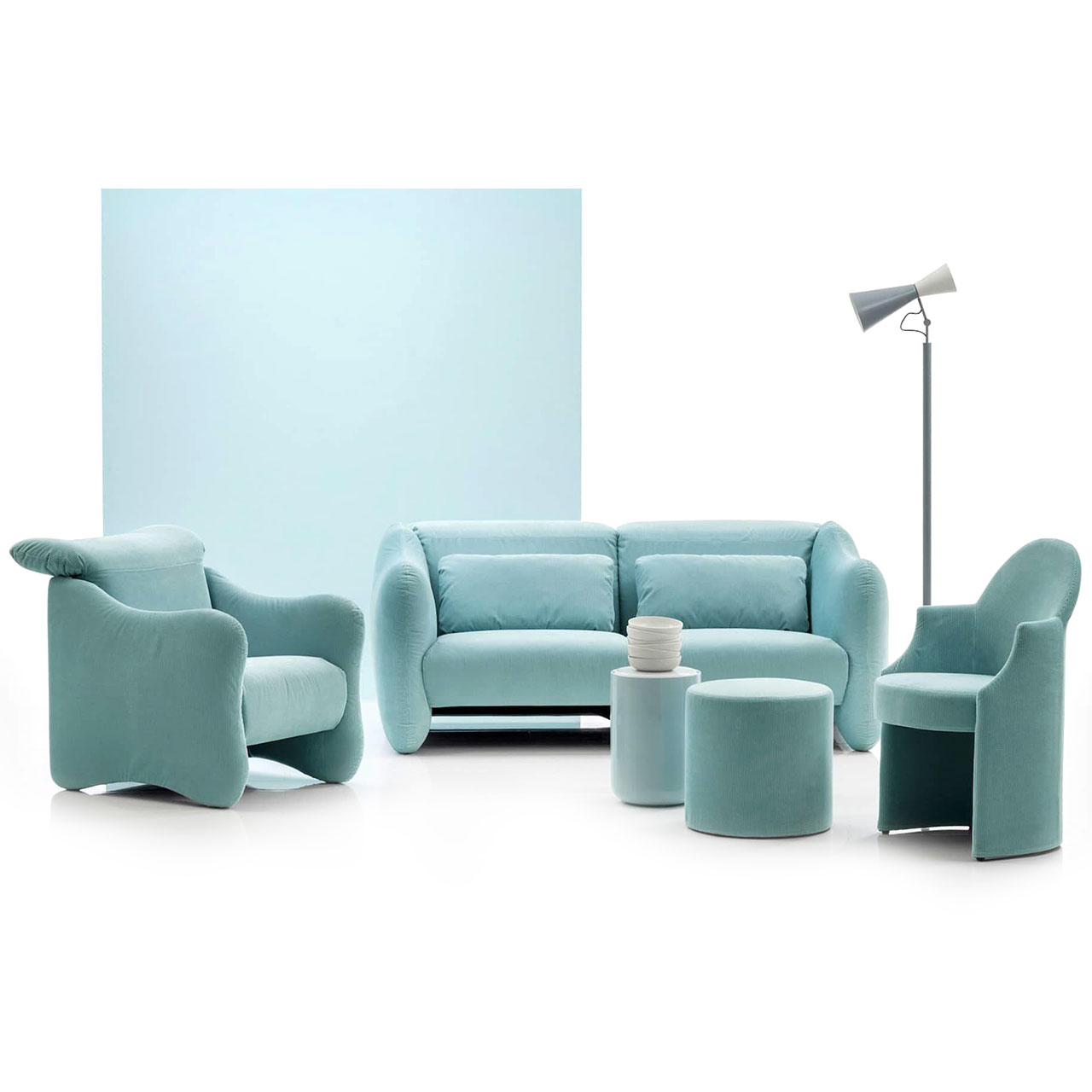 Ambientebild: Zwei Sessel und ein Sofa in hellblauem Stoff stehen in einer Gruppe beisammen.