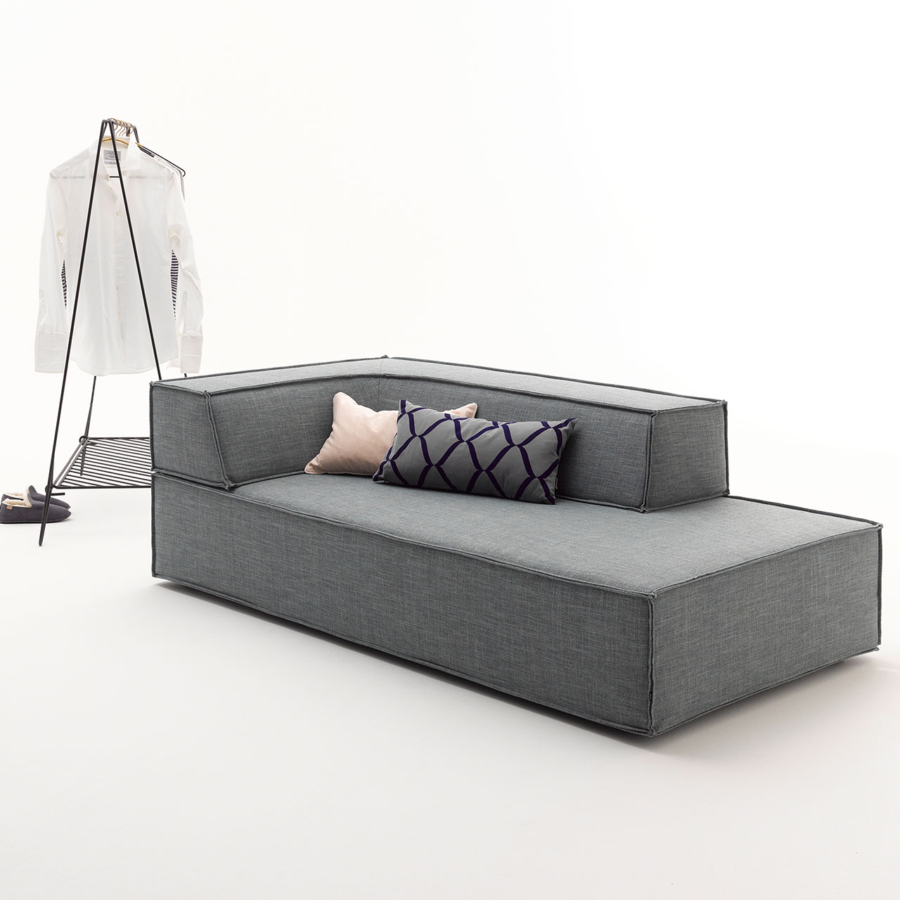 Graues Schlafelement, auf dem ein eckiges Rückenelement aufliegt.