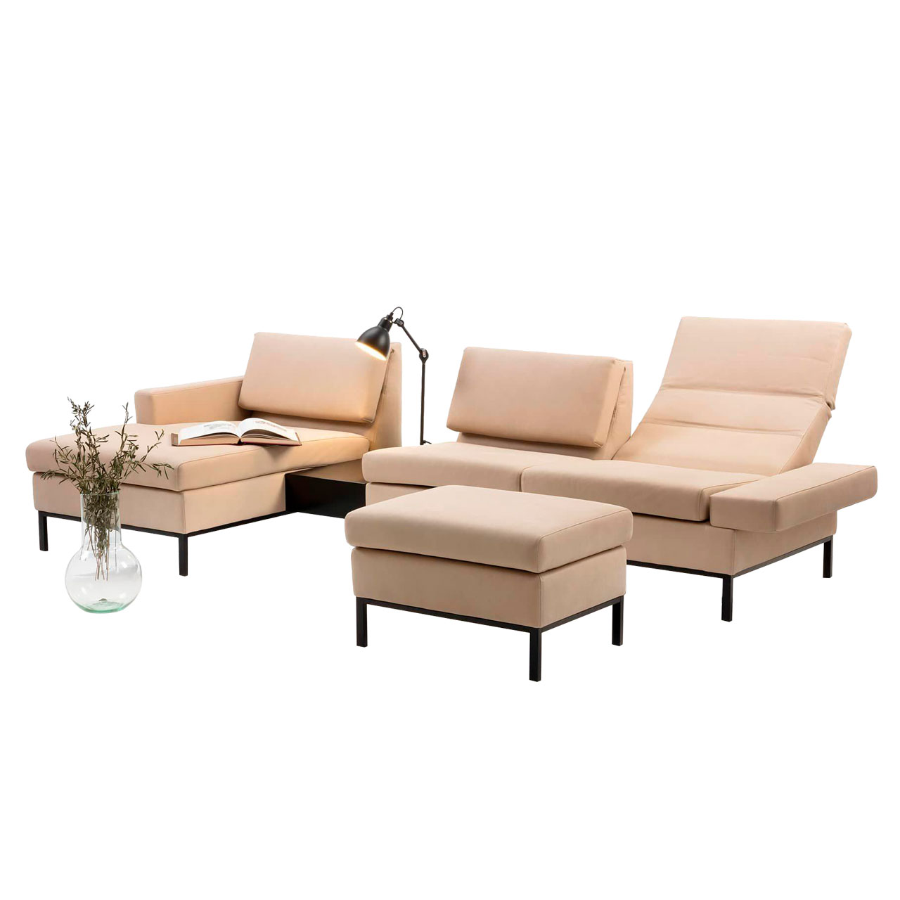 Eckgarnitur mit Longchair links und Einhängetisch. Vor dem Anstellsofa steht eine Fußbank. Die Polstermöbel sind in beigem Leder mit Untergestellen in schwarz.