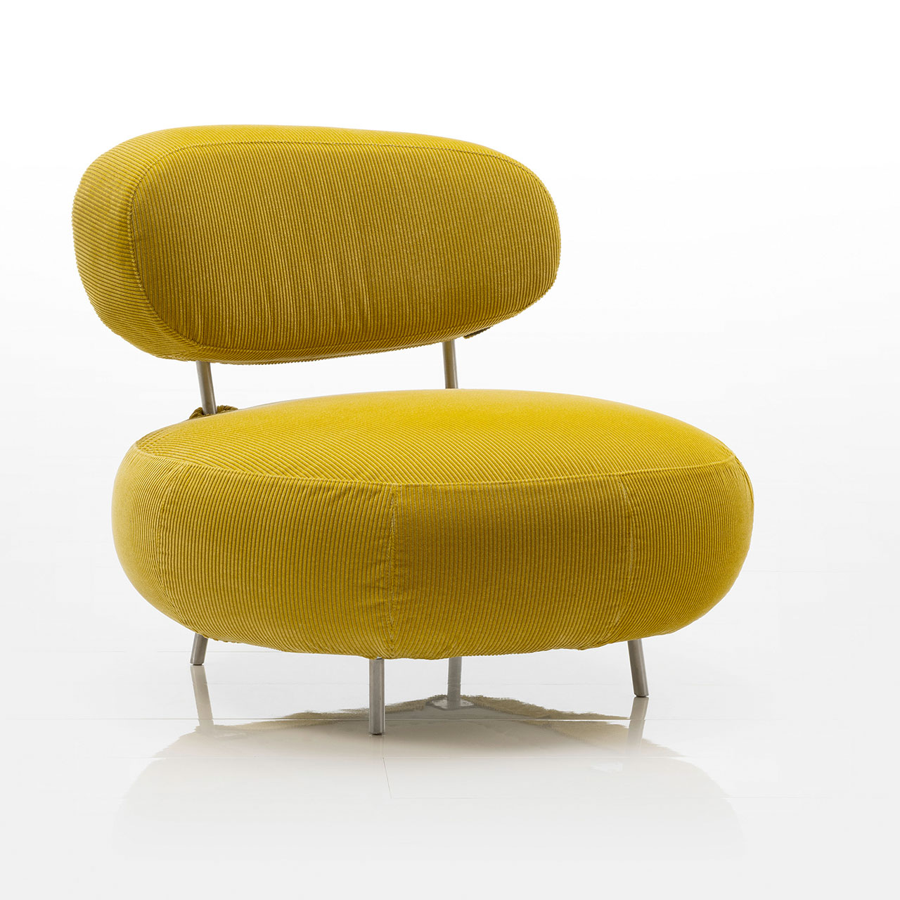 Sessel mit kurzen Füßen in Aluminium. Die Sitzbasis ist rund, die Lehne oval. Der Sessel ist in gelbem Cordstoff bezogen.
