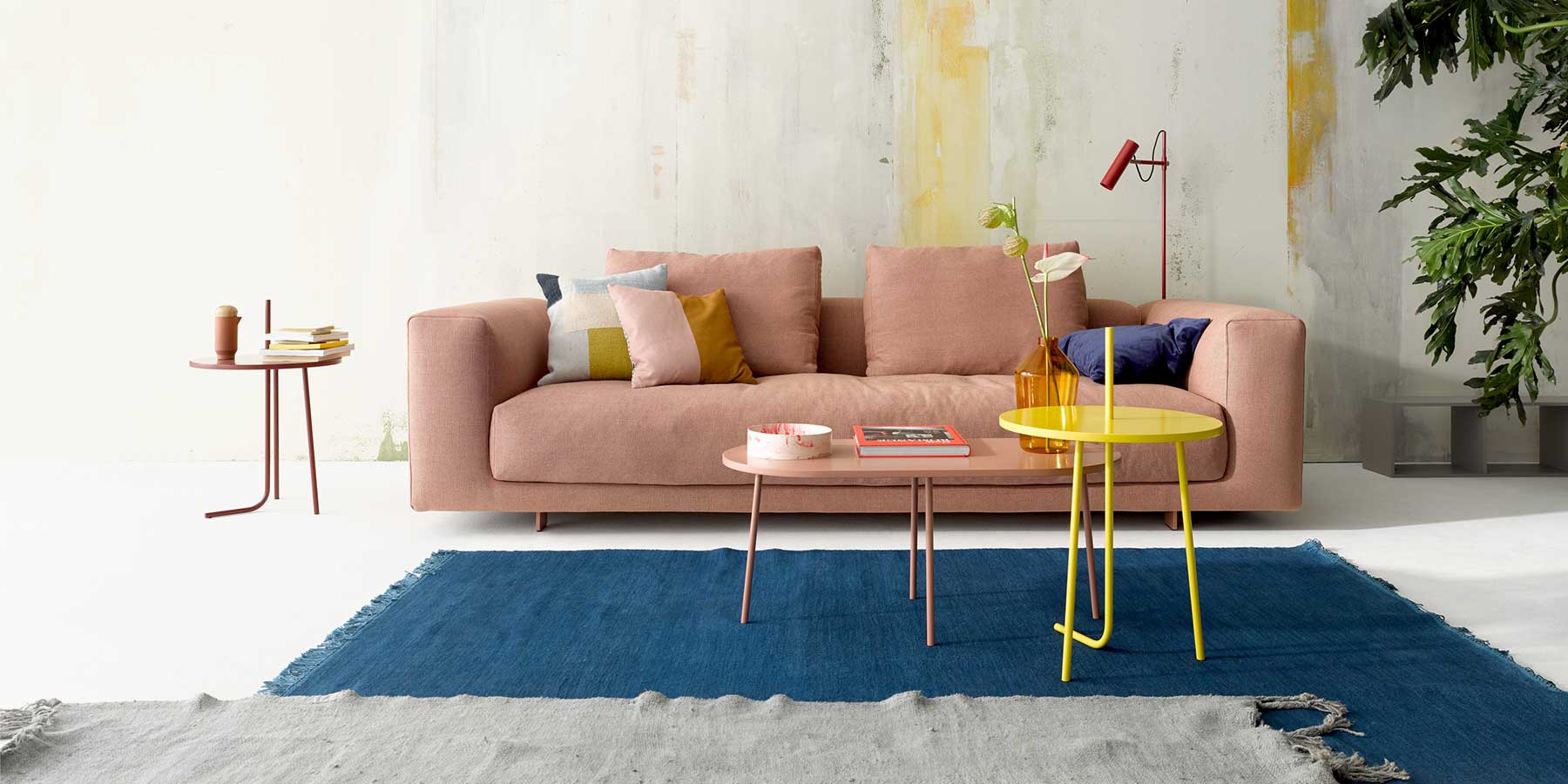 Sofa in Nude-farbenem Stoff mit vielen Kissen als Dekoration in einem Wohnzimmer