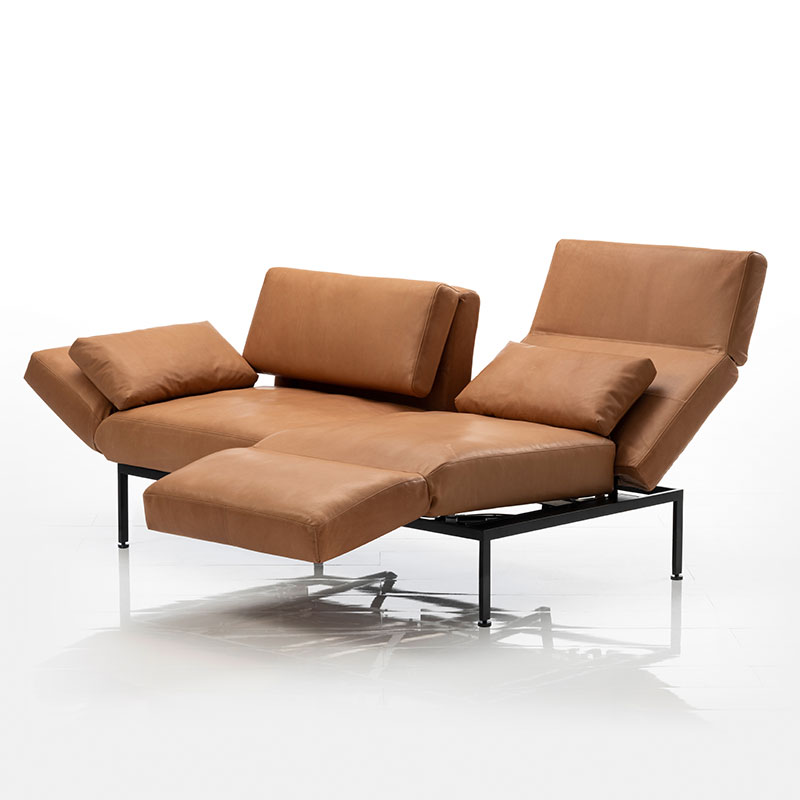 Sofa in braunem Stoff. Der rechte Sitzplatz ist zur Relaxposition umgeschwenkt.