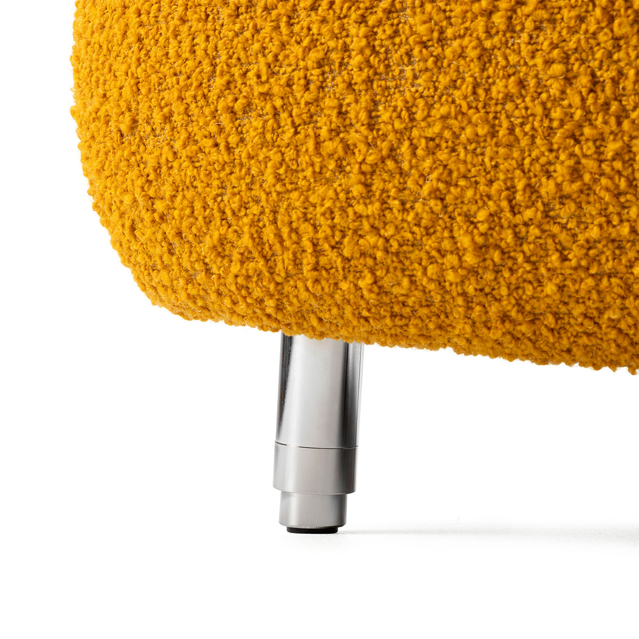 Detailaufnahme des flauschigen Stoffes und eines runden Chrom-Fußes.