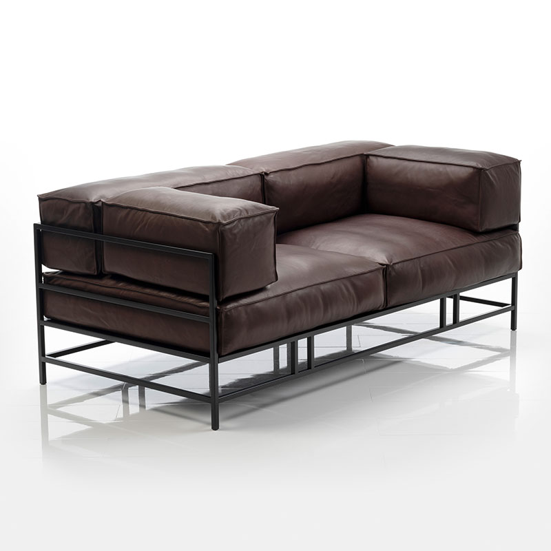 Braunes Ledersofa. Die Sitzbasis liegt nur auf dem schwarzem Metallgestell auf. Armlehnen und Rückenkissen sind kubisch und ebenfalls nur aufgelegt.
