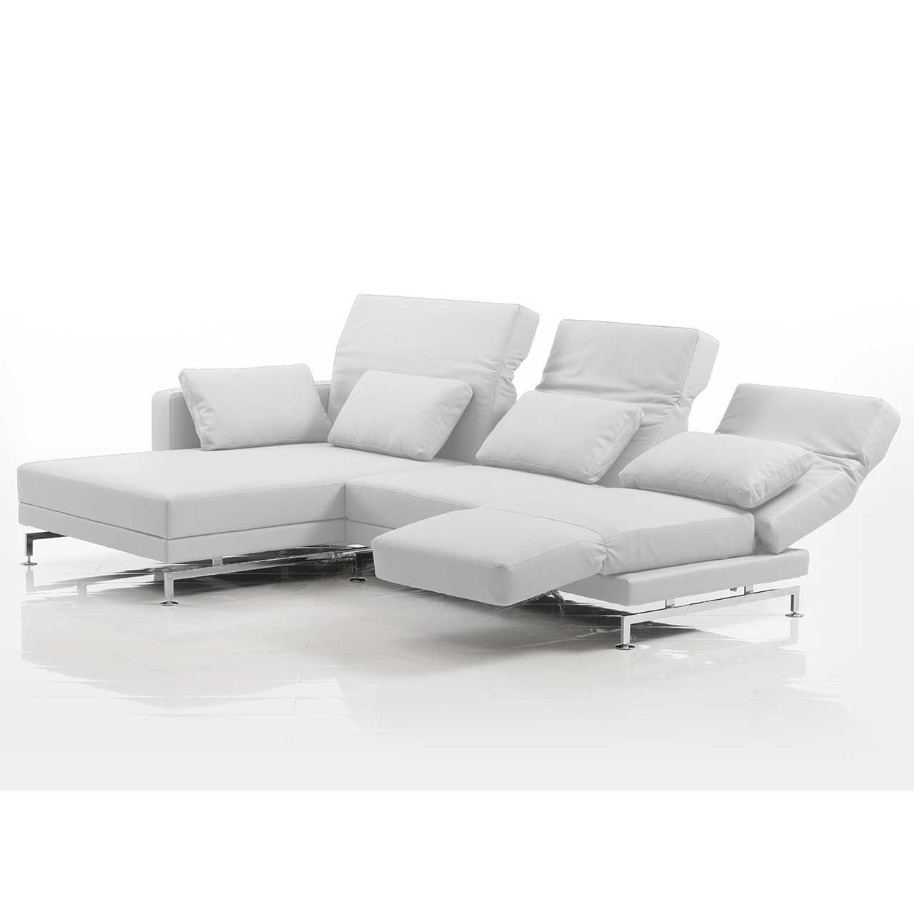 Eckgarnitur mit breitem Longchair links in weißem Leder. Die mittlere und rechte Rückenlehne sind teilweise abgesenkt. Die rechte Armlehne ist zur Fußstütze vorgeschwenkt.