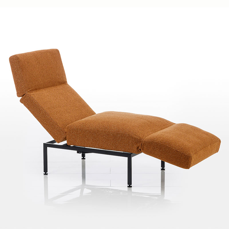 Zum Longchair aufgeschwenkter Sessel roro small soft in orange-braunem Stoff.