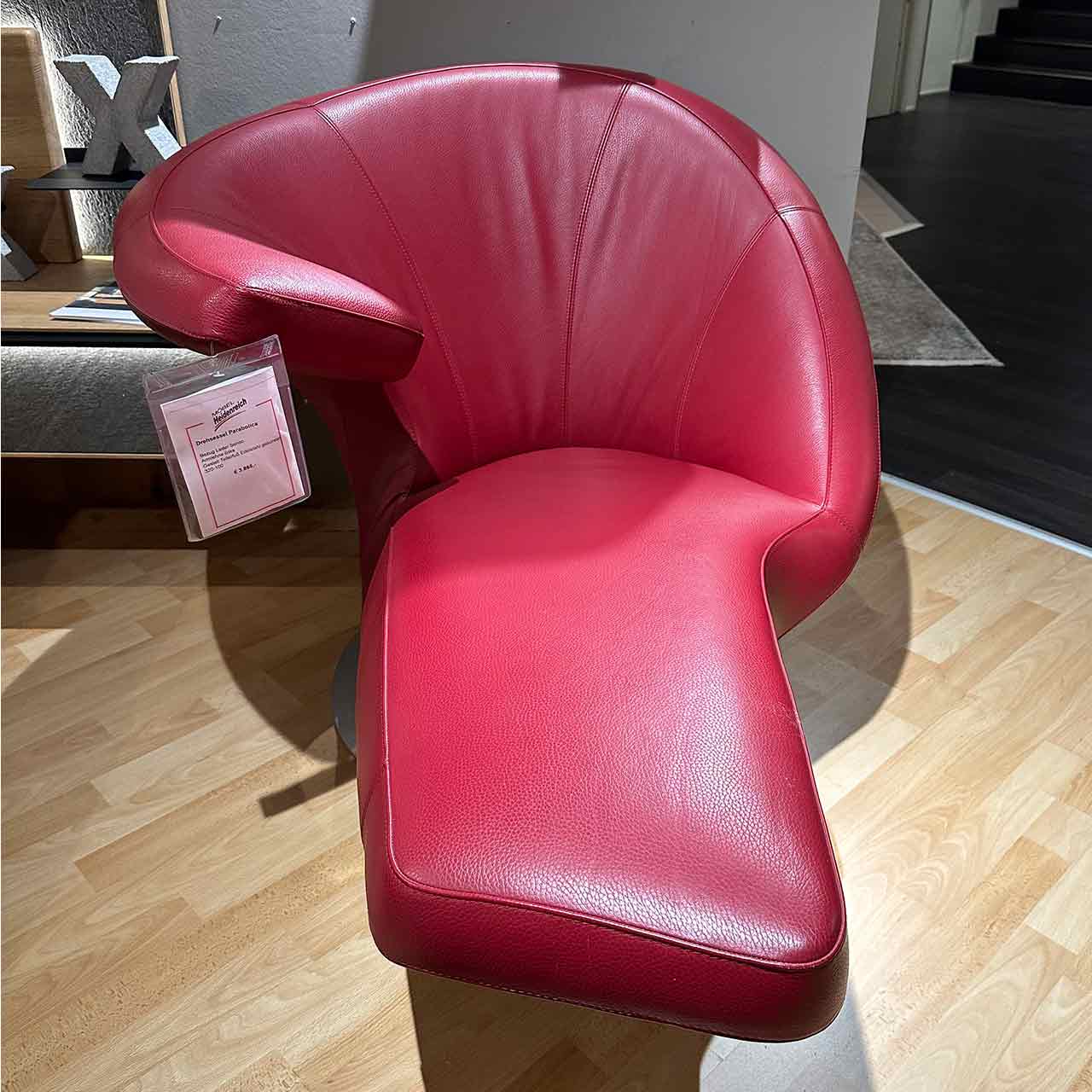 Frontalaufnahme des roten Ledersessels mit ausladendem Fußteil.
