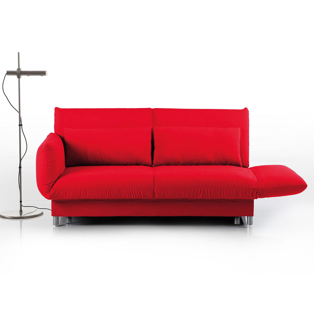 Ein rotes Bettsofa mit rechts abgeklappter Armlehne. Links neben dem Sofa steht eine Stehlampe.