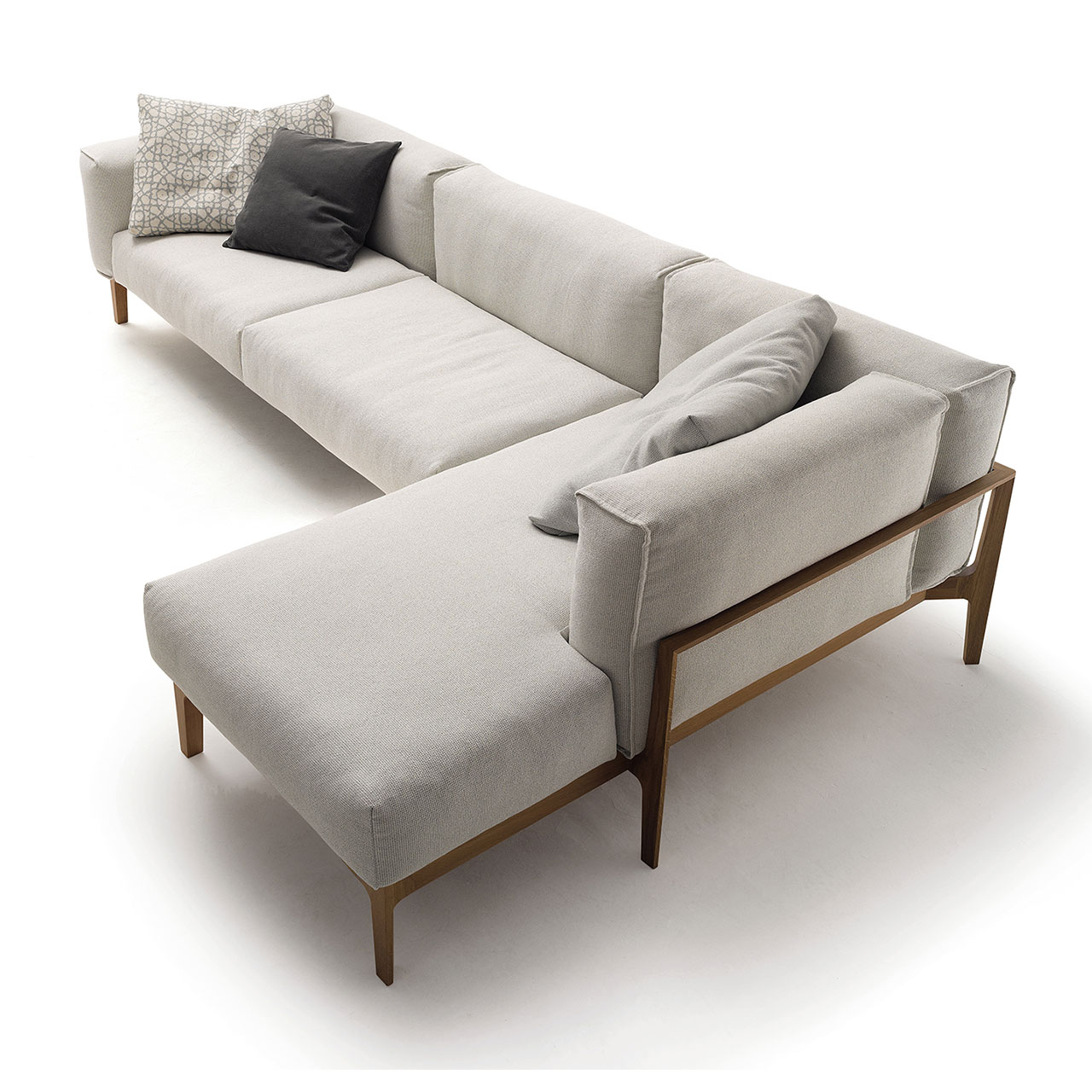 Links Zweisitzer-Sofa, rechts eine Recamiere, beides aus hellem Stoff auf einem Holzgestell. Dekoration Kissen.