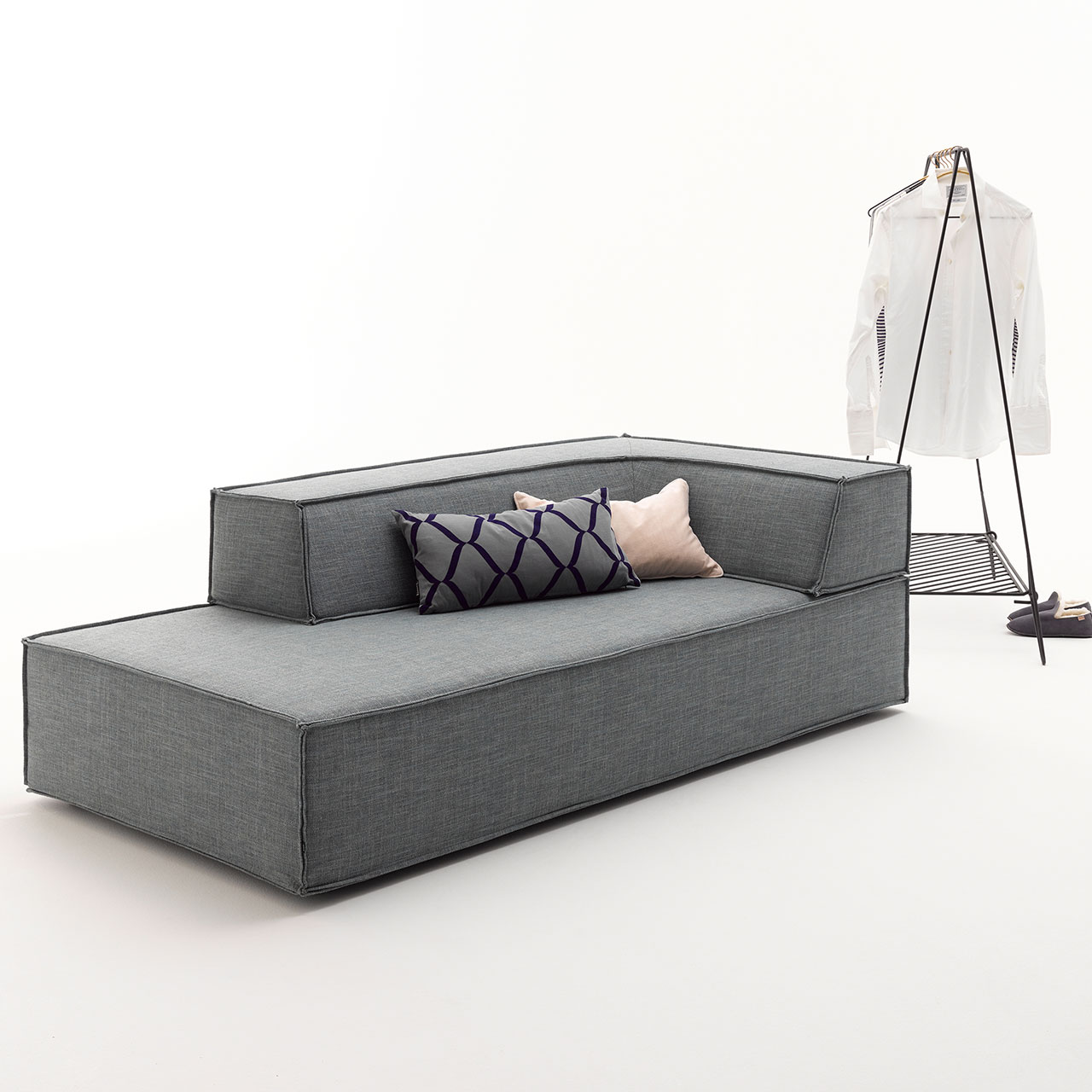 Graues Schlafelement, auf dem ein eckiges Rückenelement aufliegt.