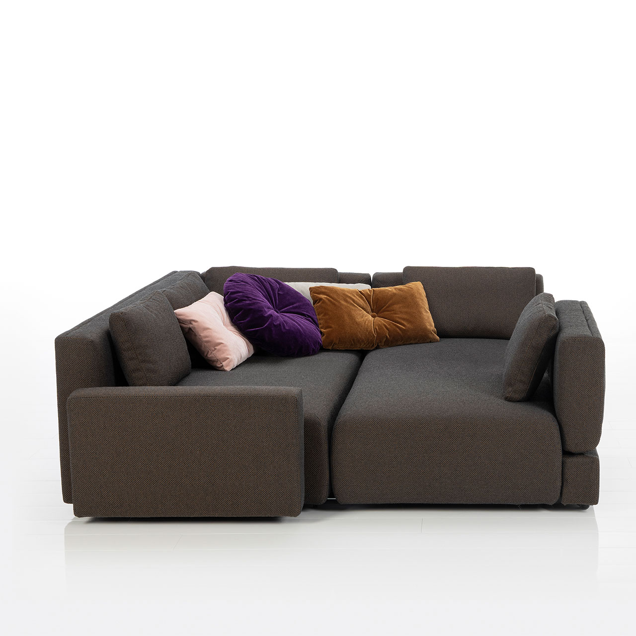 Bodennahes braunes Eckofa mit Longchair links und Drehsofa rechts. Das Drehsofa ist zum Longchair vorgeschwenkt.