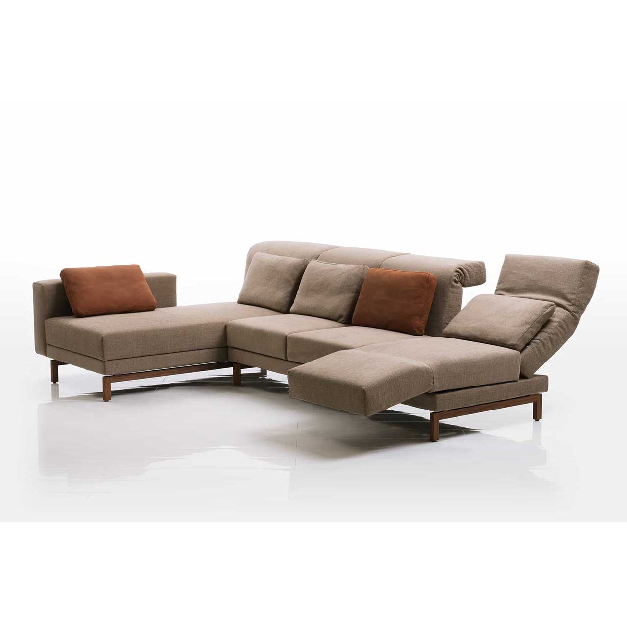 Eckgarnitur in hellbraunem Stoff mit Longchair links. Die Armlehne des Longchairs ist bis zum Fußende vorgeschoben. Die rechte Rückenlehne ist halb abgesenkt. Die rechte Armlehne ist zur Relaxposition vorgeschwenkt. 