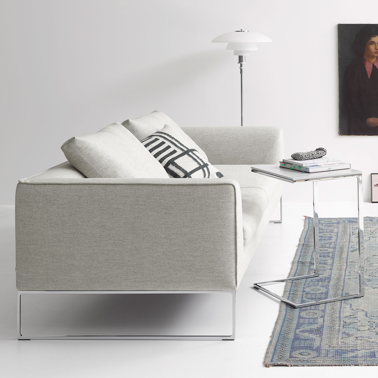 Sofa aus grauem Stoff auf verchromten Kufen