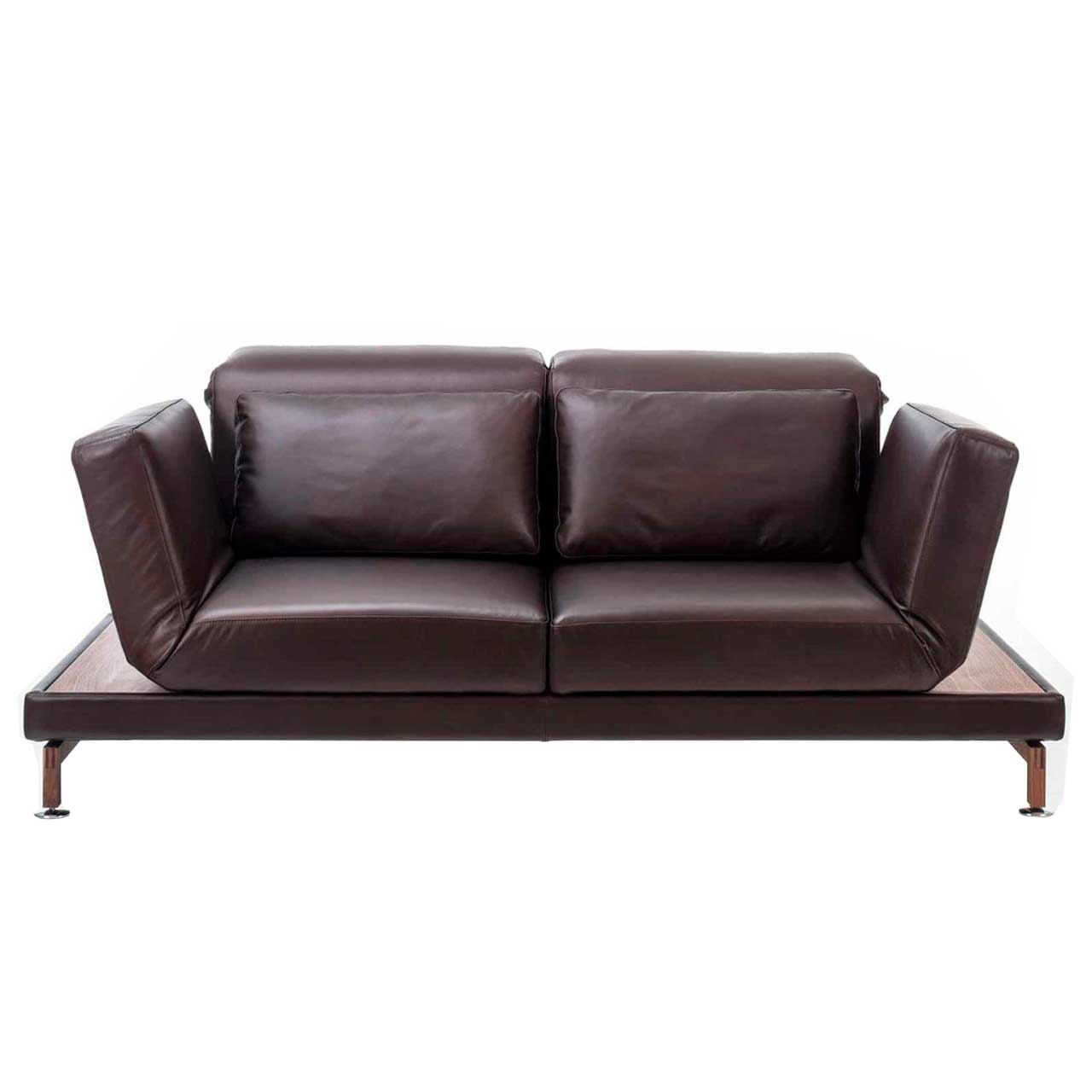 Dunkelbraunes Ledersofa von brühl moule medium. Rechts und links neben den Armlehnen befinden sich schmale Ablageflächen in dunklem Holz.