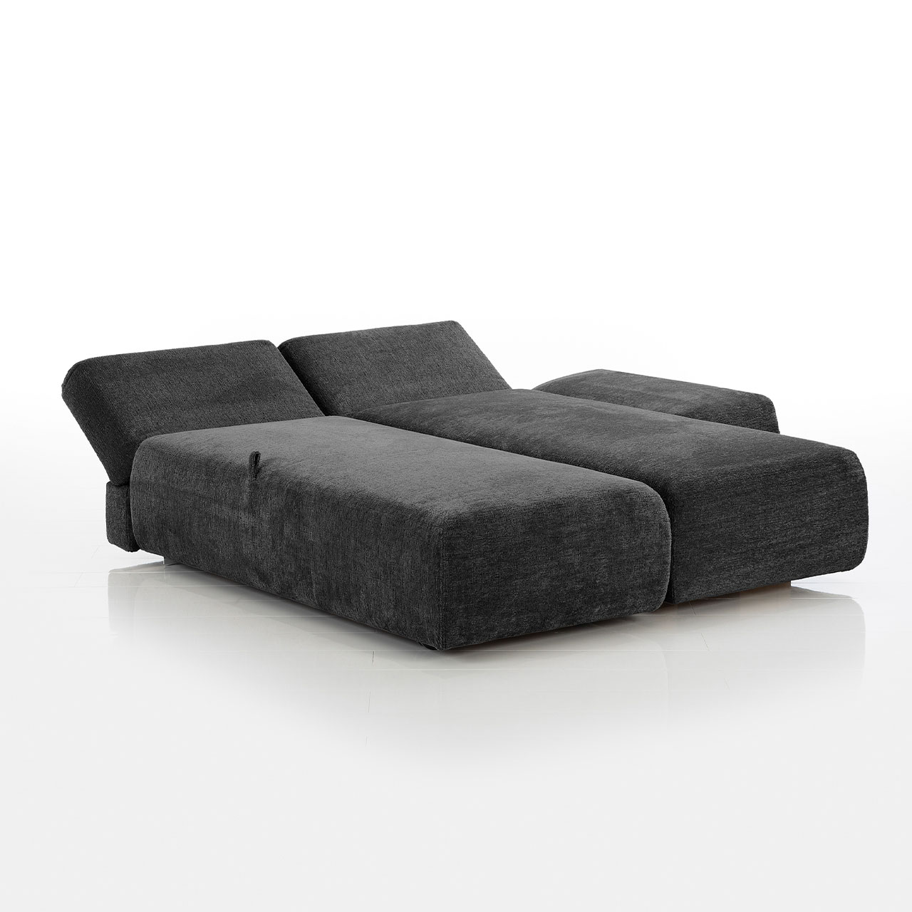 Bodennahes schwarzes Eckofa mit Drehsofa links und Longchair rechts. Das Drehsofa ist zum Longchair vorgeschwenkt.