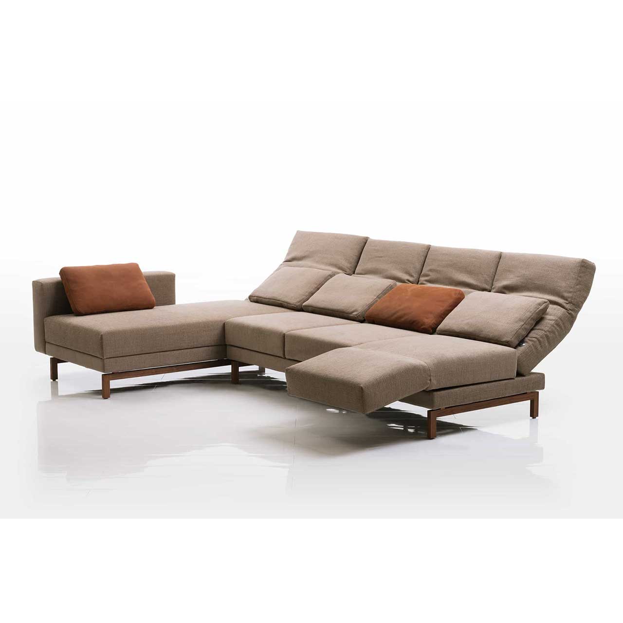 Eckgarnitur in hellbraunem Stoff mit Longchair links. Die Armlehne des Longchairs ist bis zum Fußende vorgeschoben. Die Rückenlehnen sind alle halb abgesenkt. Die rechte Armlehne ist zur Relaxposition vorgeschwenkt. 