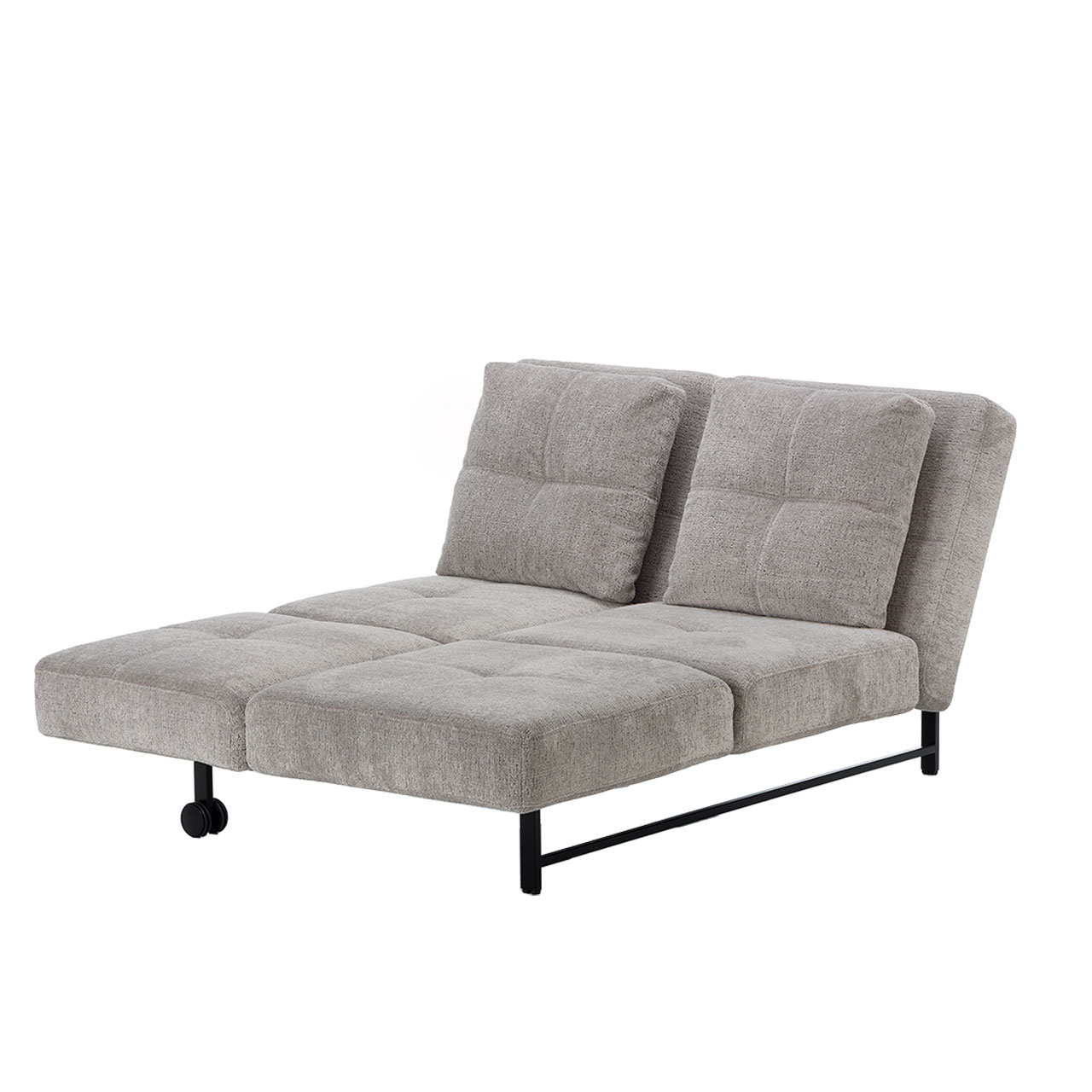 Leicht schräge Sicht auf ein zur Liege umgeklapptes Sofa in einem sehr hellen Braunton. Das Rückenteil ist hochgestellt. Zwei große quadratische Kissen sind an das Rückenteil angelehnt. Die Doppelliege hat ein schwarzes Metallgestell.