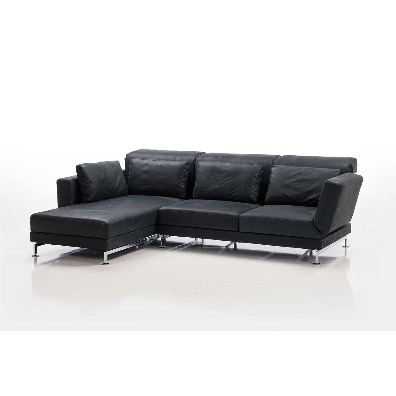 Eckgarnitur von brühl moule medium in schwarzem Leder mit Longchair links, dekoriert mit vier Kissen.