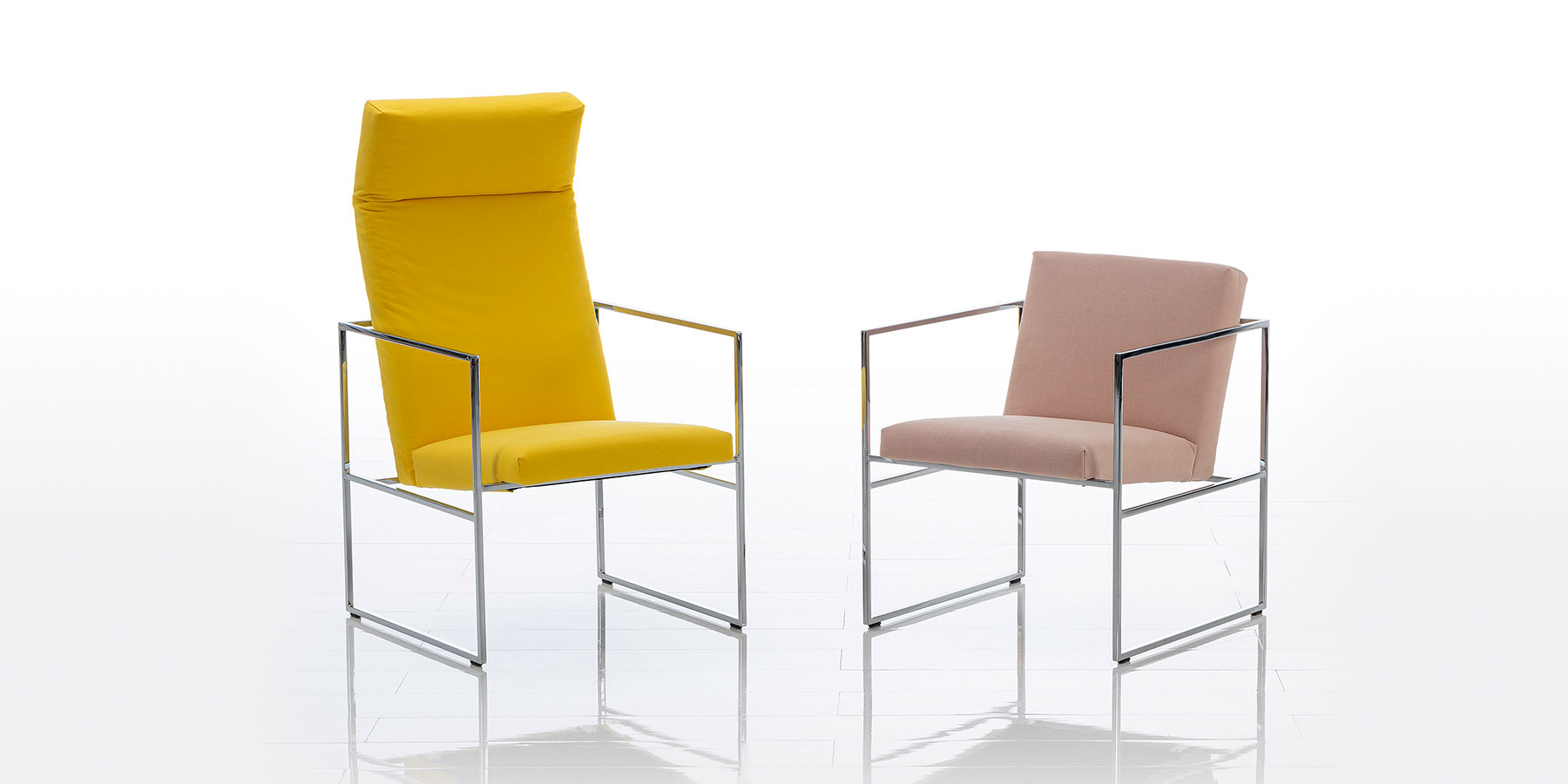 Ein Hochlehnsessel in gelbem Stoff und ein Sessel mit niedriger Rückenlehne und Stoff in rosé. Das Gestell beider Sessel ist aus filigranem Edelstahl.