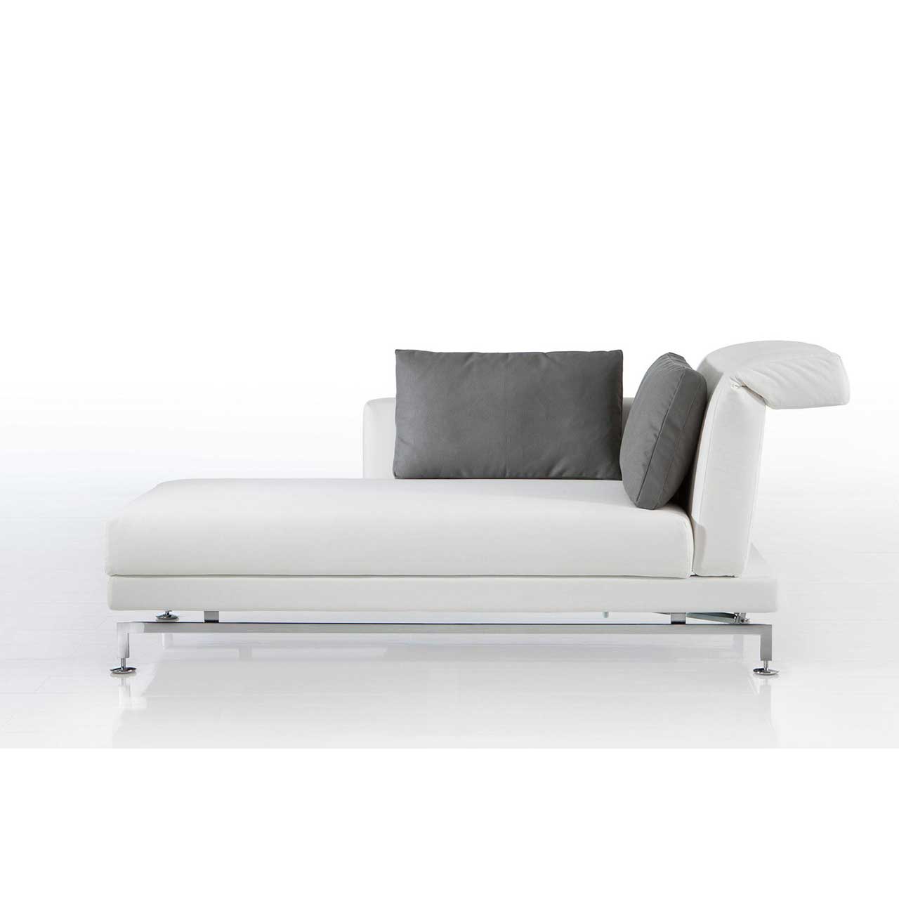 Longchair mit Kufen in chrom glänzendem Metall und mit weißem Leder bezogen. Auf dem Longchair liegen zwei Kissen mit grauem Bezug.