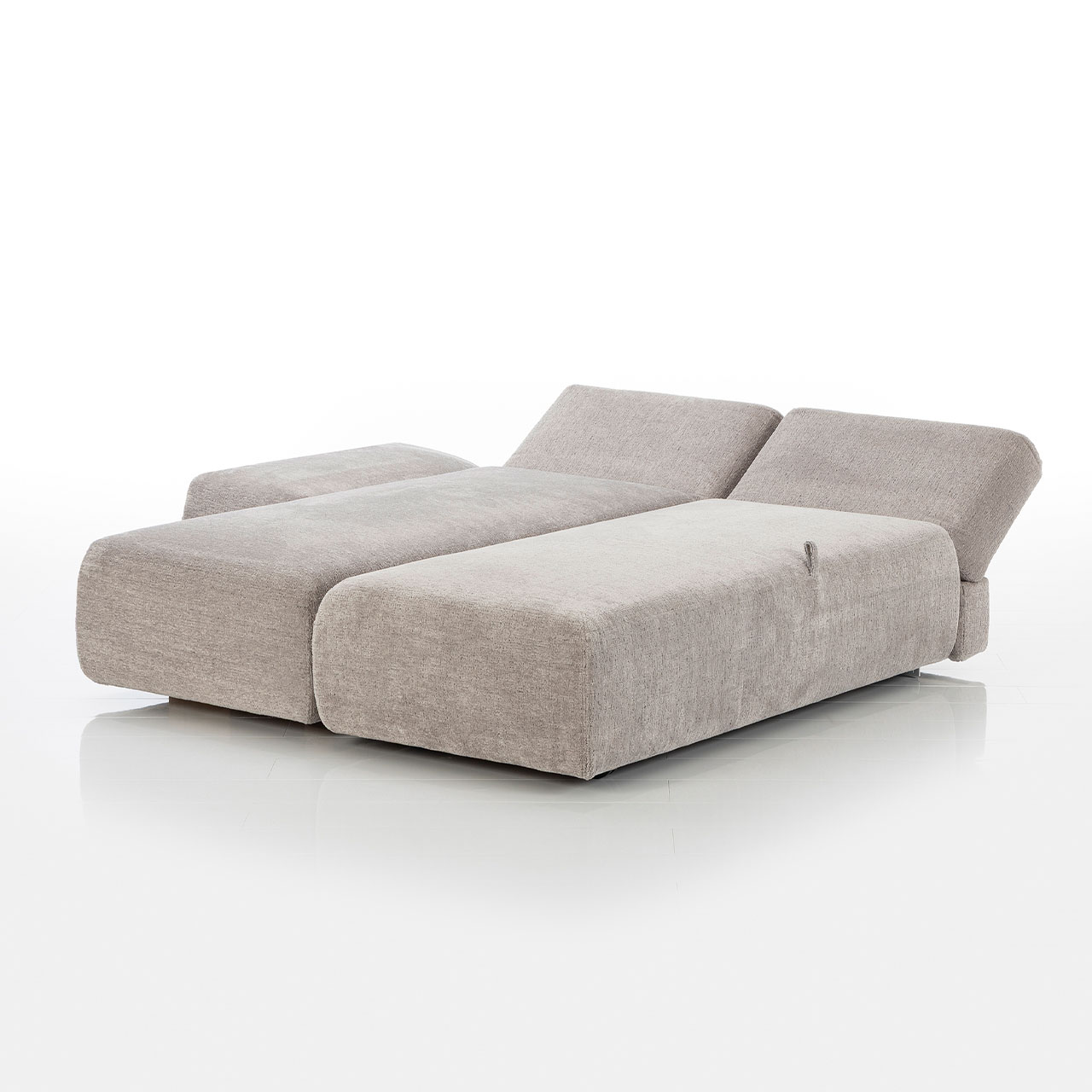 Bodennahes beiges Eckofa mit Longchair links und Drehsofa rechts. Das Drehsofa ist zum Longchair vorgeschwenkt.