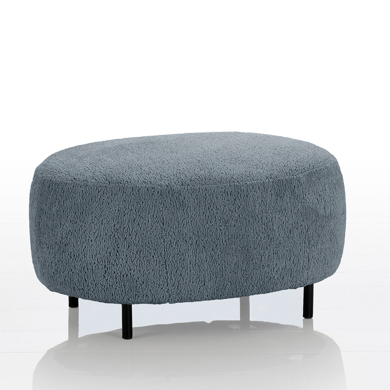 Ovaler Hocker von brühl aoyama mit schwarzen Metallfüßen. Die Sitzfläche ist in einem blaugrauen Stoff gearbeitet.