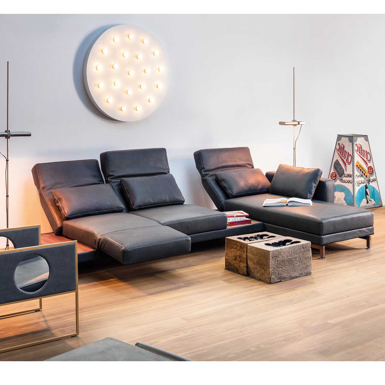 Eckgarnitur von brühl moule medium in schwarzem Leder mit Longchair rechts und mit Ablagefläche zwischen Longchair und Anstellsofa.