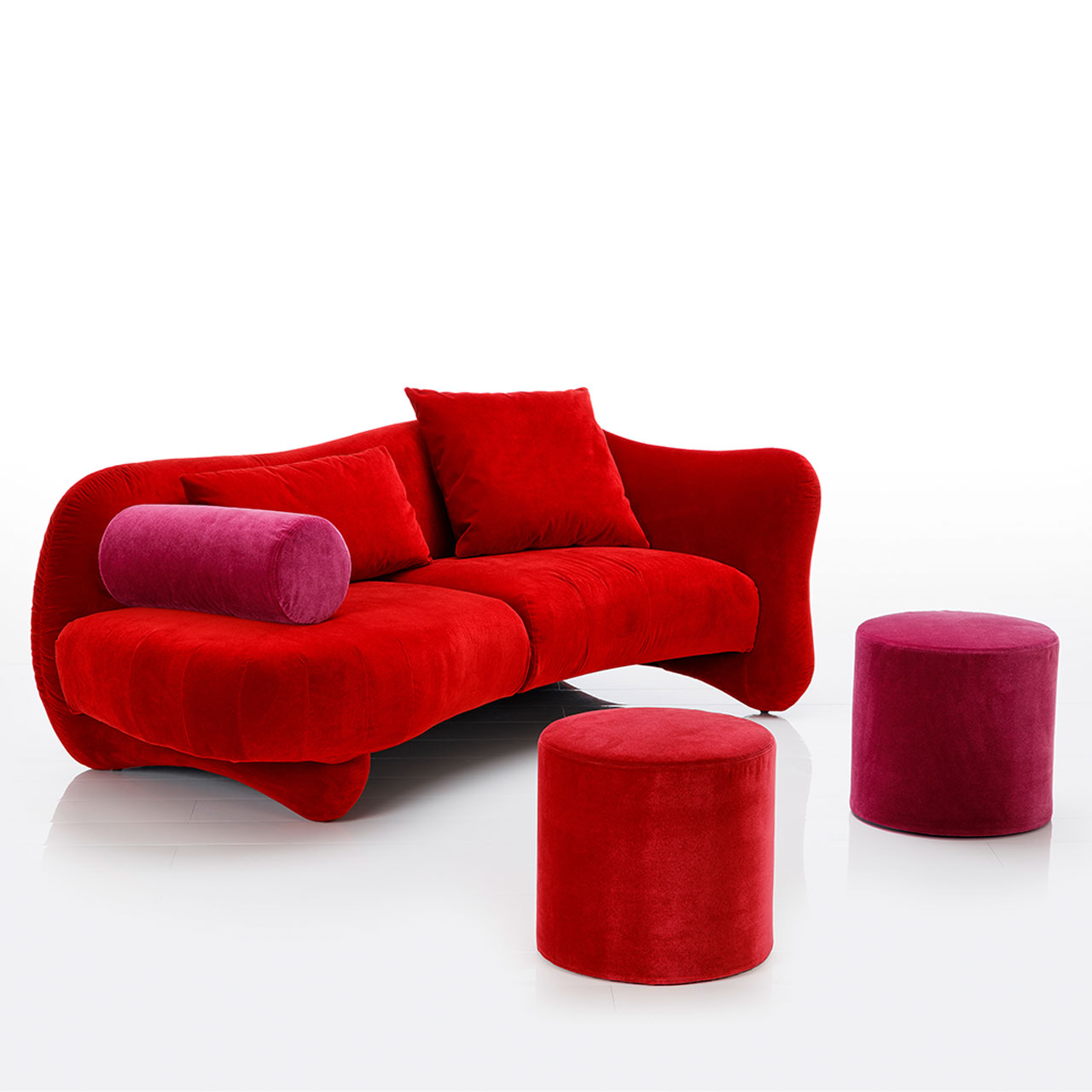 Openend mit Armlehne rechts. Auf der linken Seite ist eine Armlehnrolle angebracht. Davor stehen zwei Hocker.