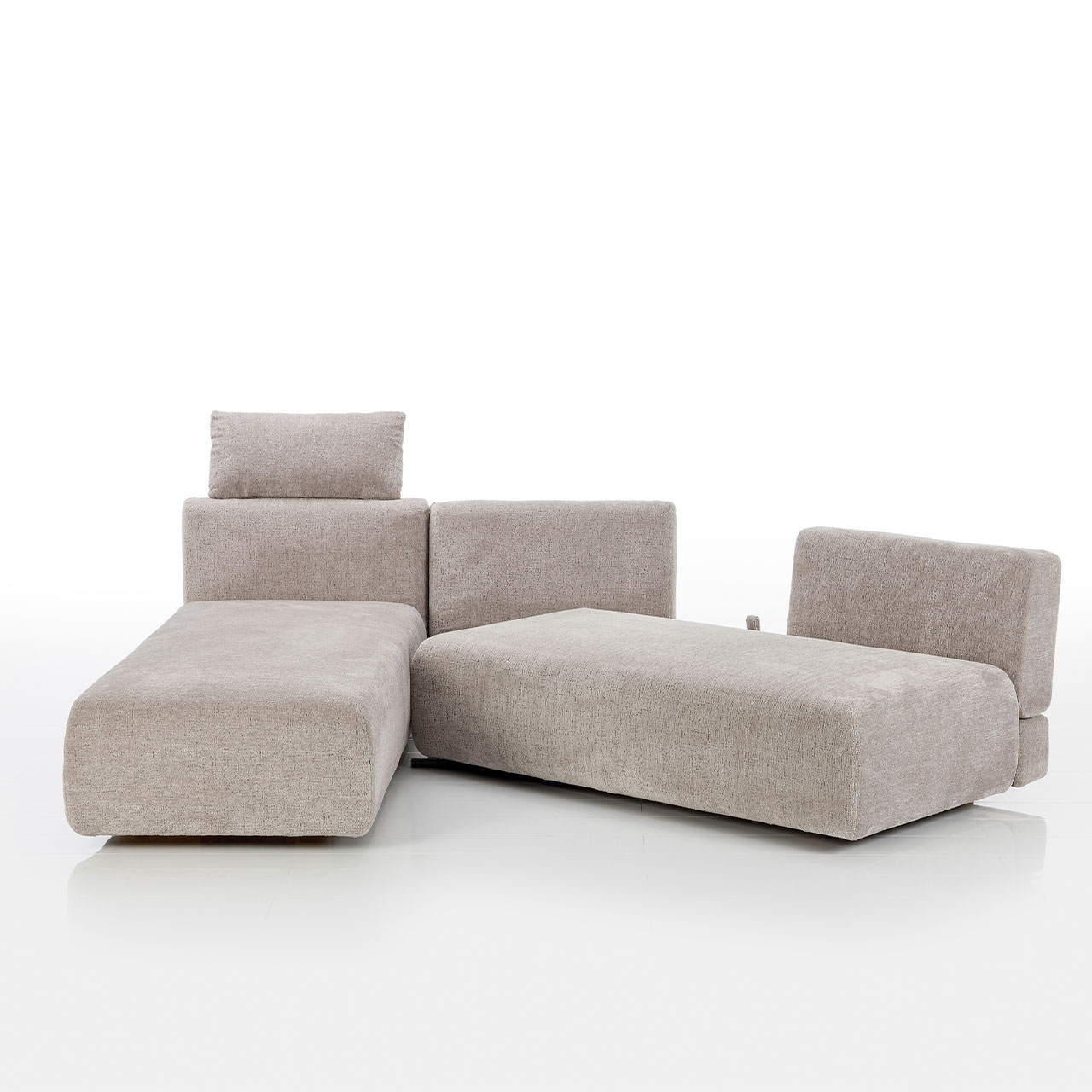 Bodennahes beiges Eckofa mit Longchair links und Drehsofa rechts.  Das Drehsofa ist im 45 Grad Winkel zum Longchair vorgeschwenkt.