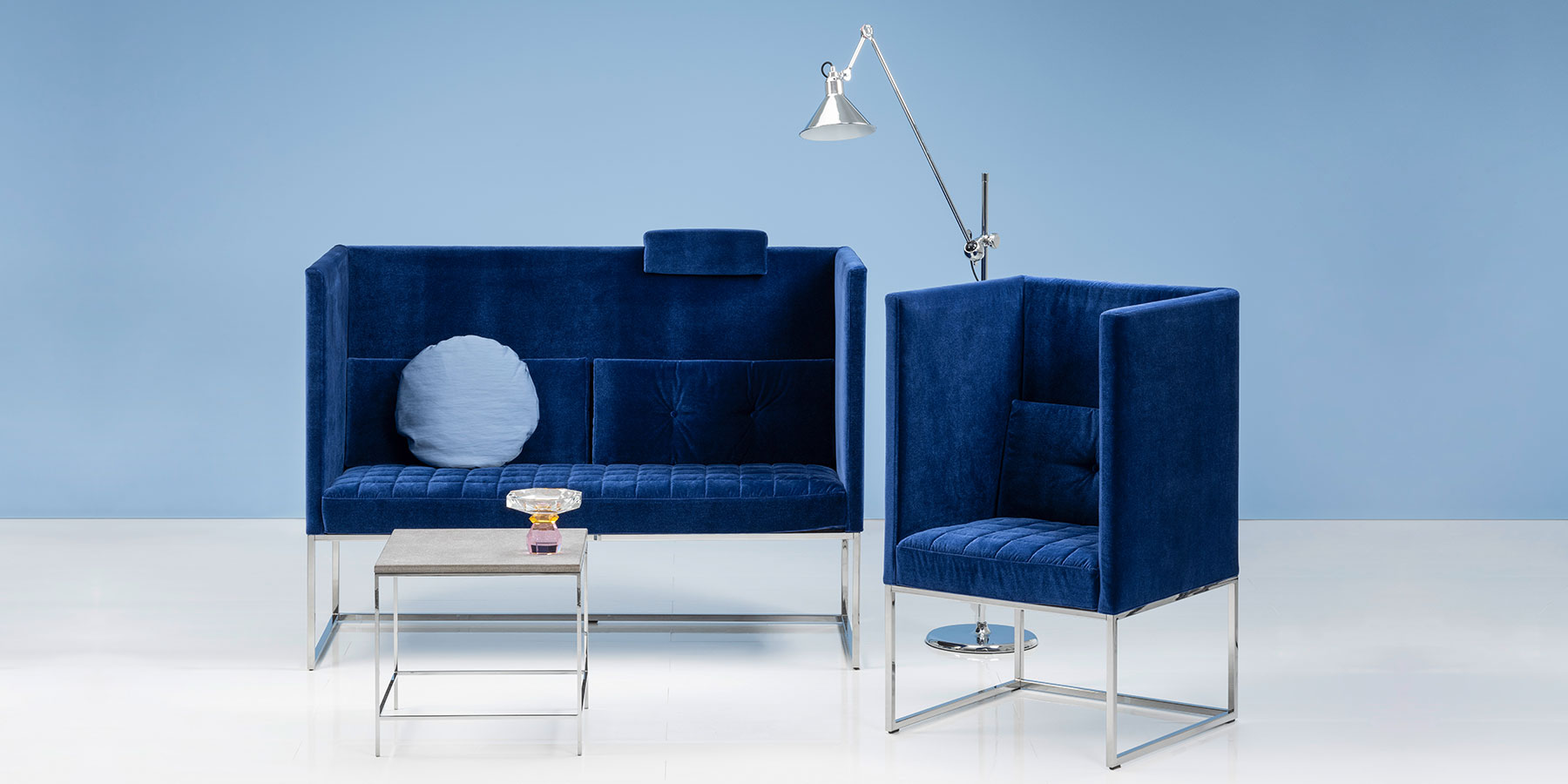 Eine Sitzbank und ein Stuhl von brühl belami high in dunkelblauem Stoff.