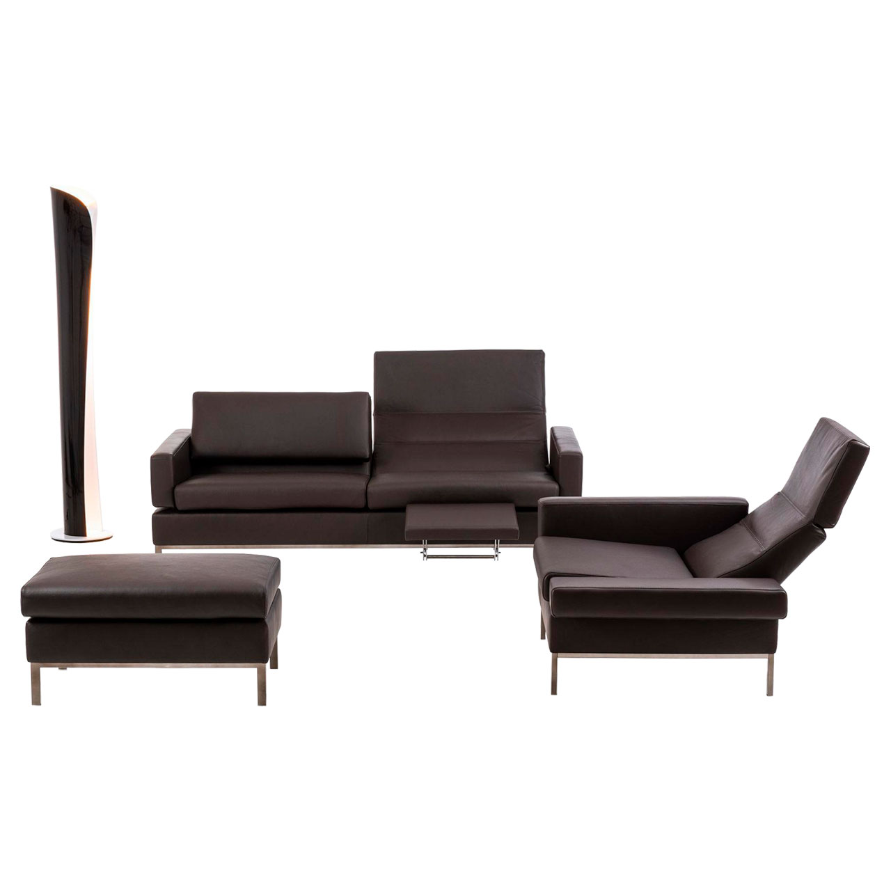 Sofa, Sessel und Hocker der Serie brühl tomo in dunkelbraunem Leder. Das Sofa steht quer im Hintergrund, rechts davor ist der Sessel um 90 Grad gedreht zum Sofa und links vor dem Sofa steht der Hocker