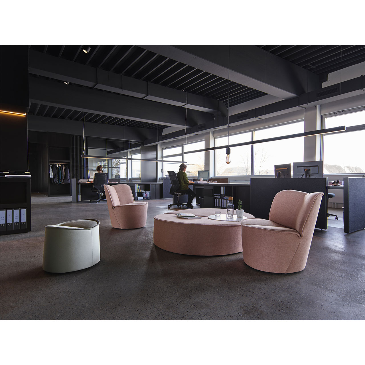 Zwei Sessel und zwei Hocker in einem großzügigen Büromilieu platziert