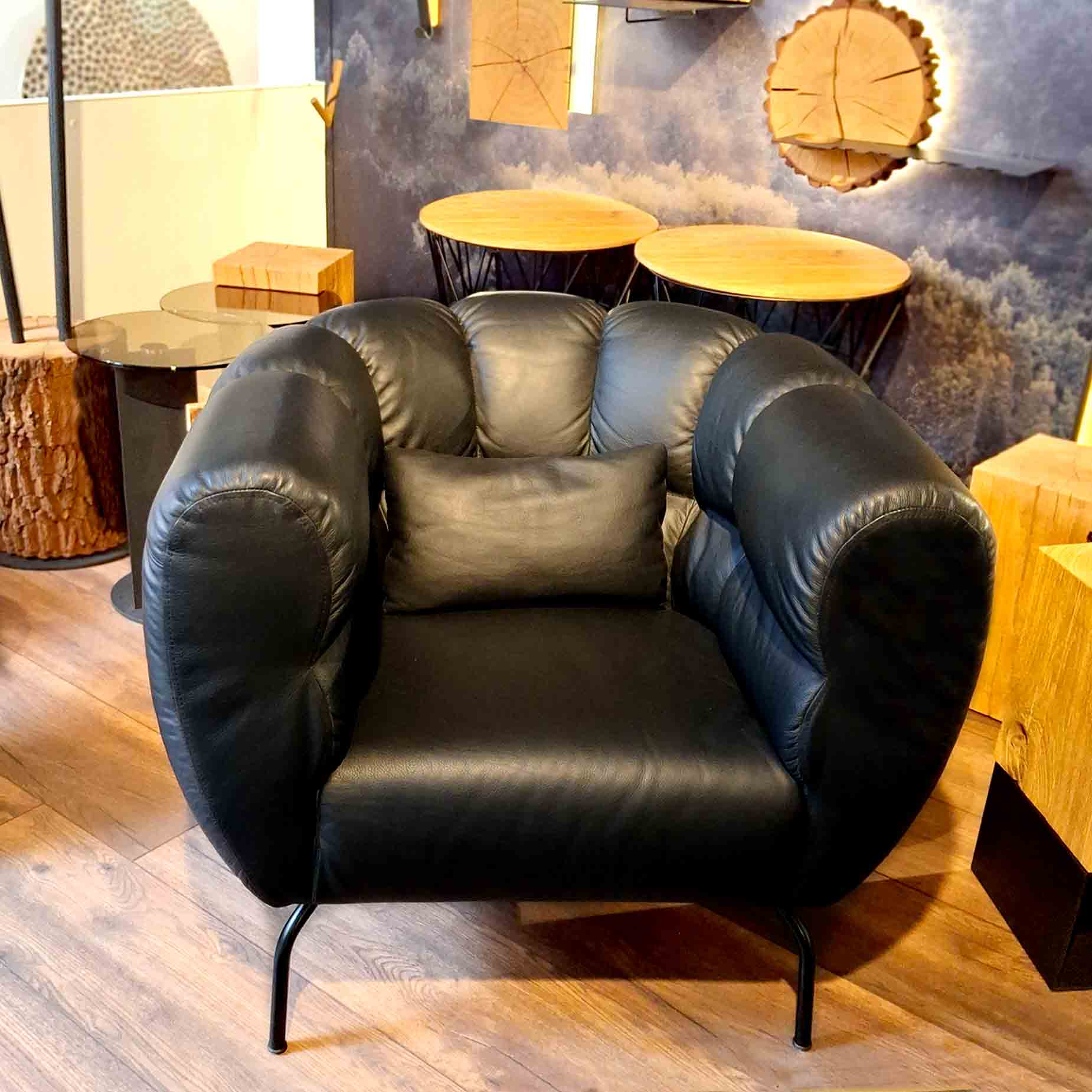 Sessel von brühl mit umschließender Lehne in schwarzem Leder.