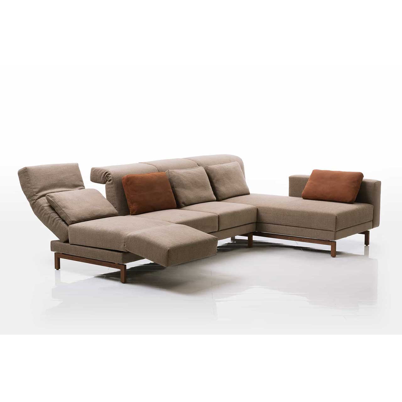 Eckgarnitur in hellbraunem Stoff mit Longchair rechts. Die Armlehne des Longchairs ist bis zum Fußende vorgeschoben. Die linke Rückenlehne ist halb abgesenkt. Die linke Armlehne ist zur Relaxposition vorgeschwenkt. 