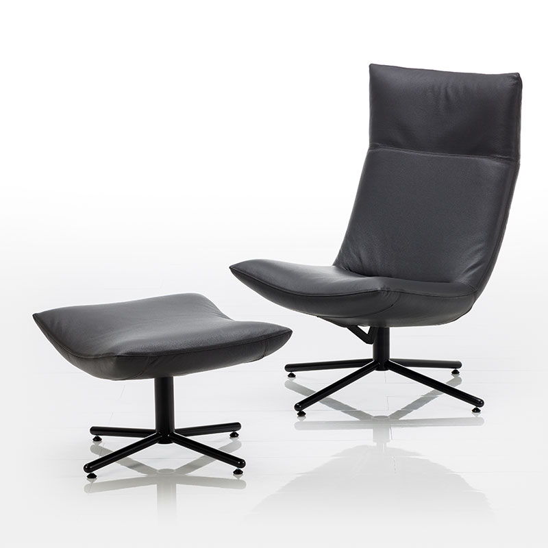 Schwarzer Drehsessel mit Kreuzfuß und ohne Armlehnen. Vor dem Sessel steht ein passender Hocker.