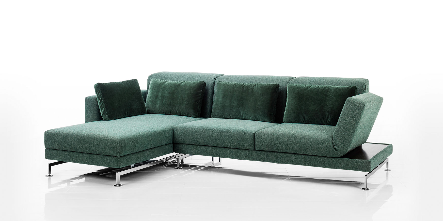 Eine Eckgarnitur bestehend aus einem Longchair und einem Anstellsofa. Der Stoff ist moosgrün, das Gestell ist Chrom glänzend.