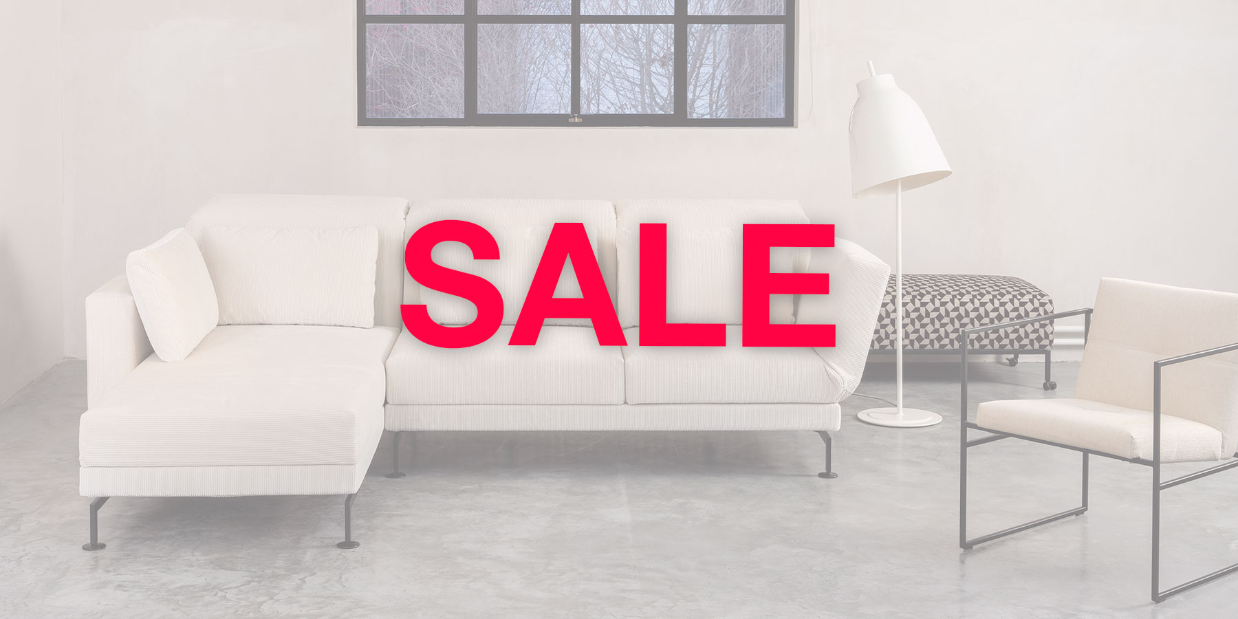 Ein cremefarbenes Ecksofa. Im Vordergrund steht in roter Schrift "Sale"