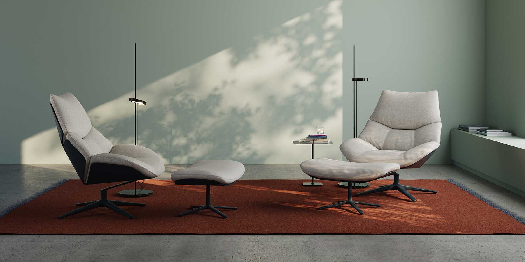 Zwei Shrimp Sessel mit Hocker davor stehen auf einem Teppich. Heller Bezug.