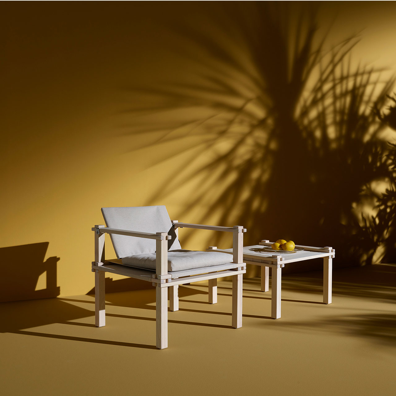 Bild eines Stuhls mit passendem Tisch im Indoor-Bereich vor gelber Wand