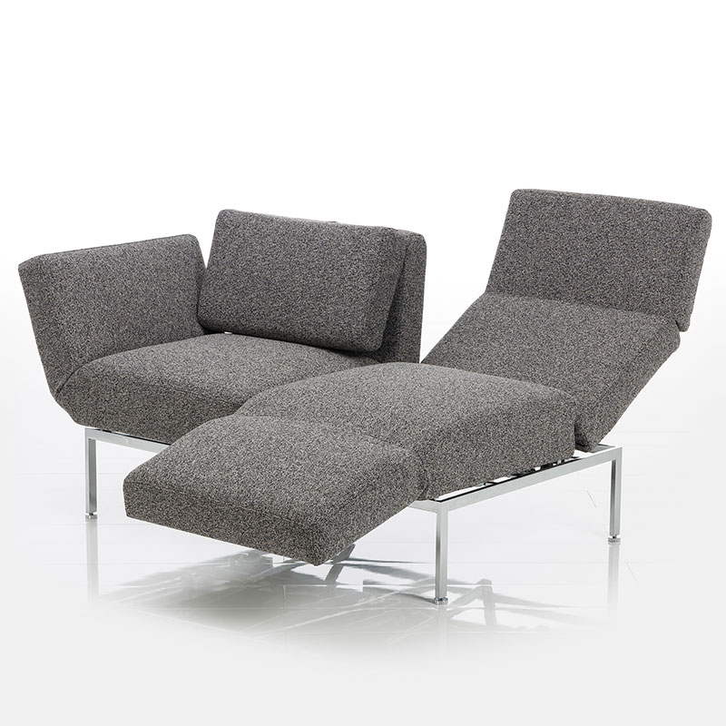 Mit grauem Stoff bezogenes Sofa. Der rechte Sitzplatz ist zur Relaxposition umgeschwenkt.